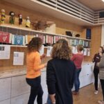 Teilnehmerinnen eines Workshops stehen vor einer Auswahl an Schildern zu Nachhaltigkeitszielen
