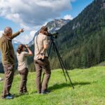 Ranger beobachten mit Spektiv Steinadler im Gebirge