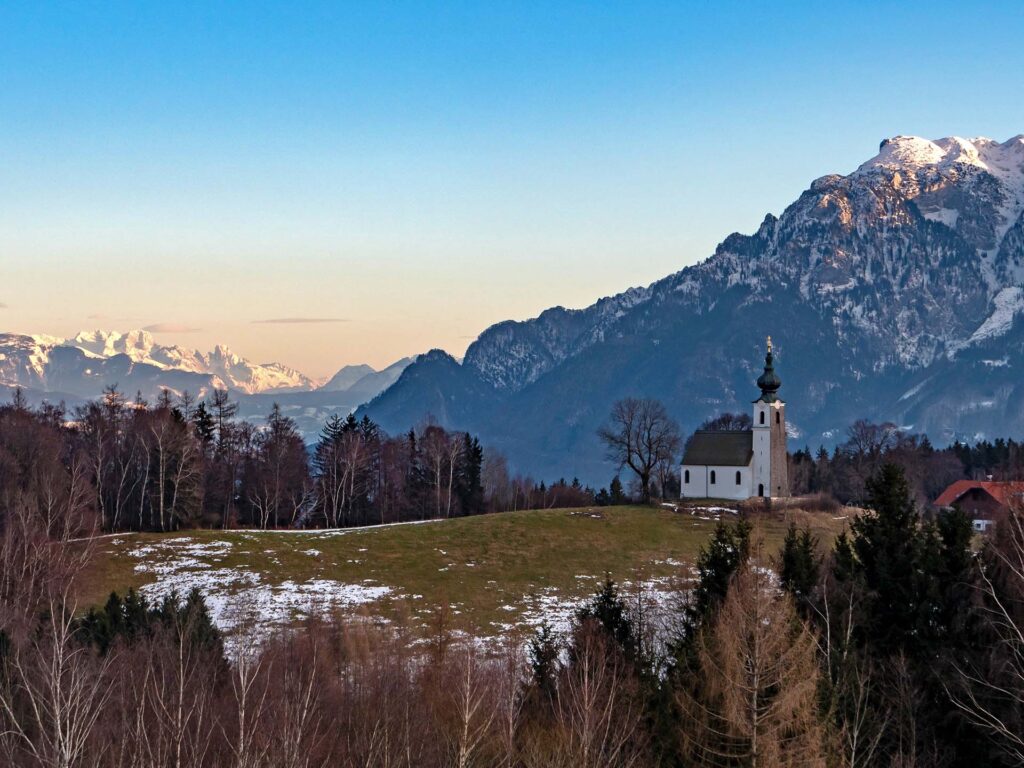 Blick über die Kirche am Högl ins winterliche Gebirge