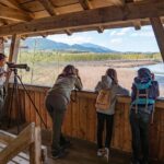 Kinder beobachten zusammen mit einer Biosphären-Rangerin Vögel im Ainringer Moos