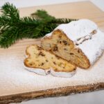 Angeschnittener Biosphären-Stollen mit Puderzucker auf einem Holzbrett