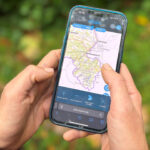 Mit der Karten-Anwendung des Bayern Atlas auf dem Smartphone unterwegs im Wald