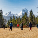 Teilnehmerinnen bei einer Barfuß-Übung während des Achtsamkeitstrainings mit Blick zum Watzmann