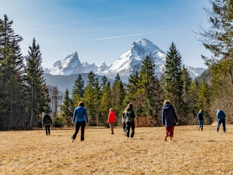 Teilnehmerinnen bei einer Barfuß-Übung während des Achtsamkeitstrainings mit Blick zum Watzmann