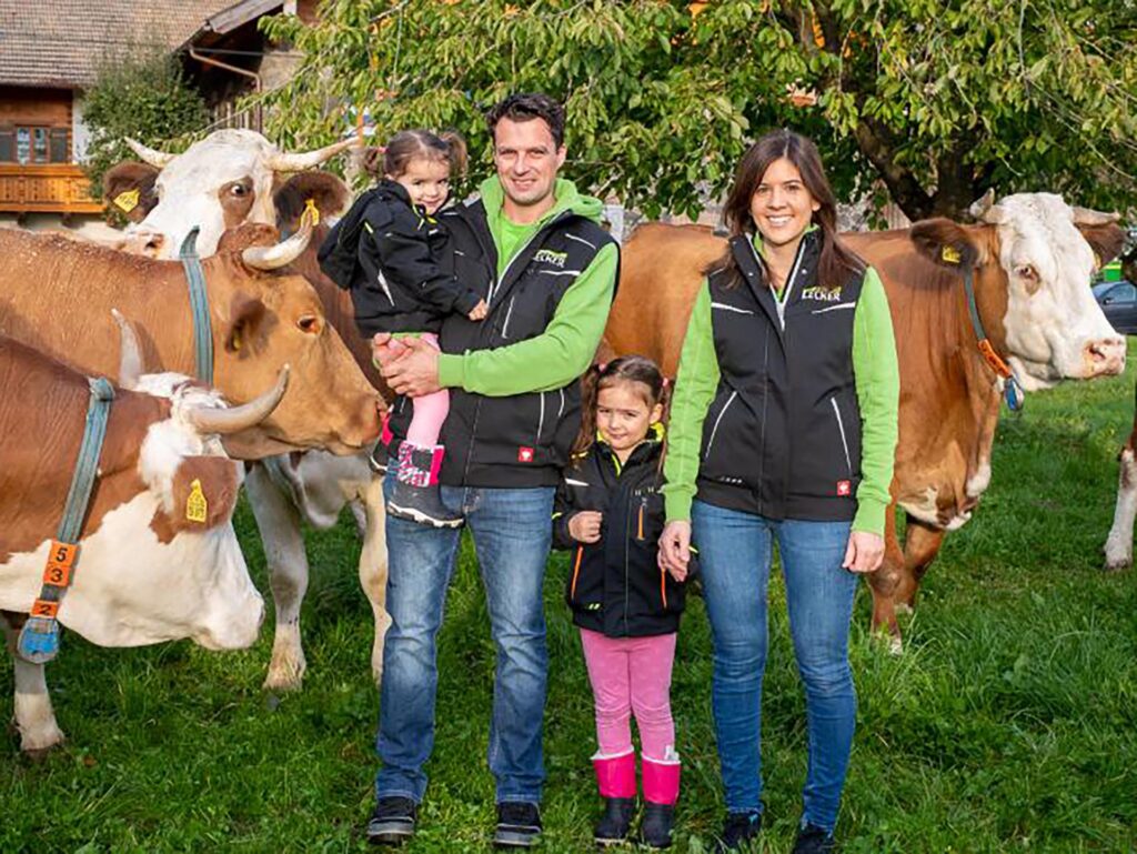 Landwirt-Familie auf einer Weide mit Kühen