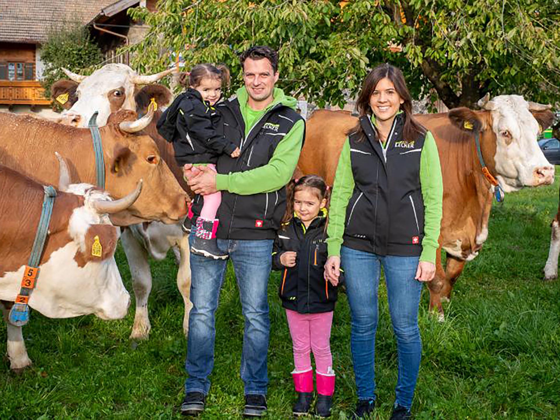 Landwirt-Familie auf einer Weide mit Kühen