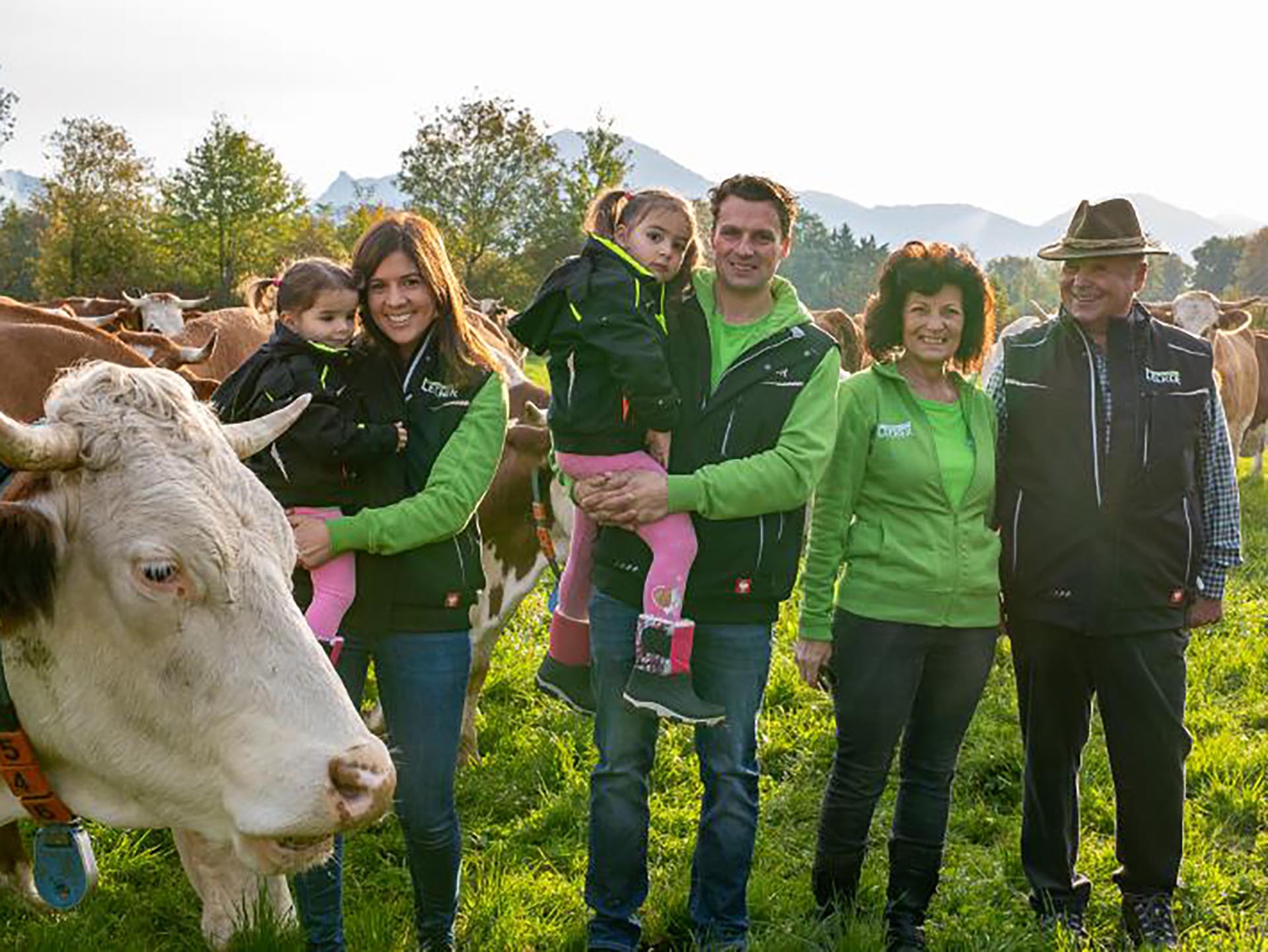 Landwirt-Familie auf einer Weide mit Kühen