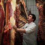 Ein Mitarbeiter des Schlachthof Laufen mit abgehangenem Fleisch